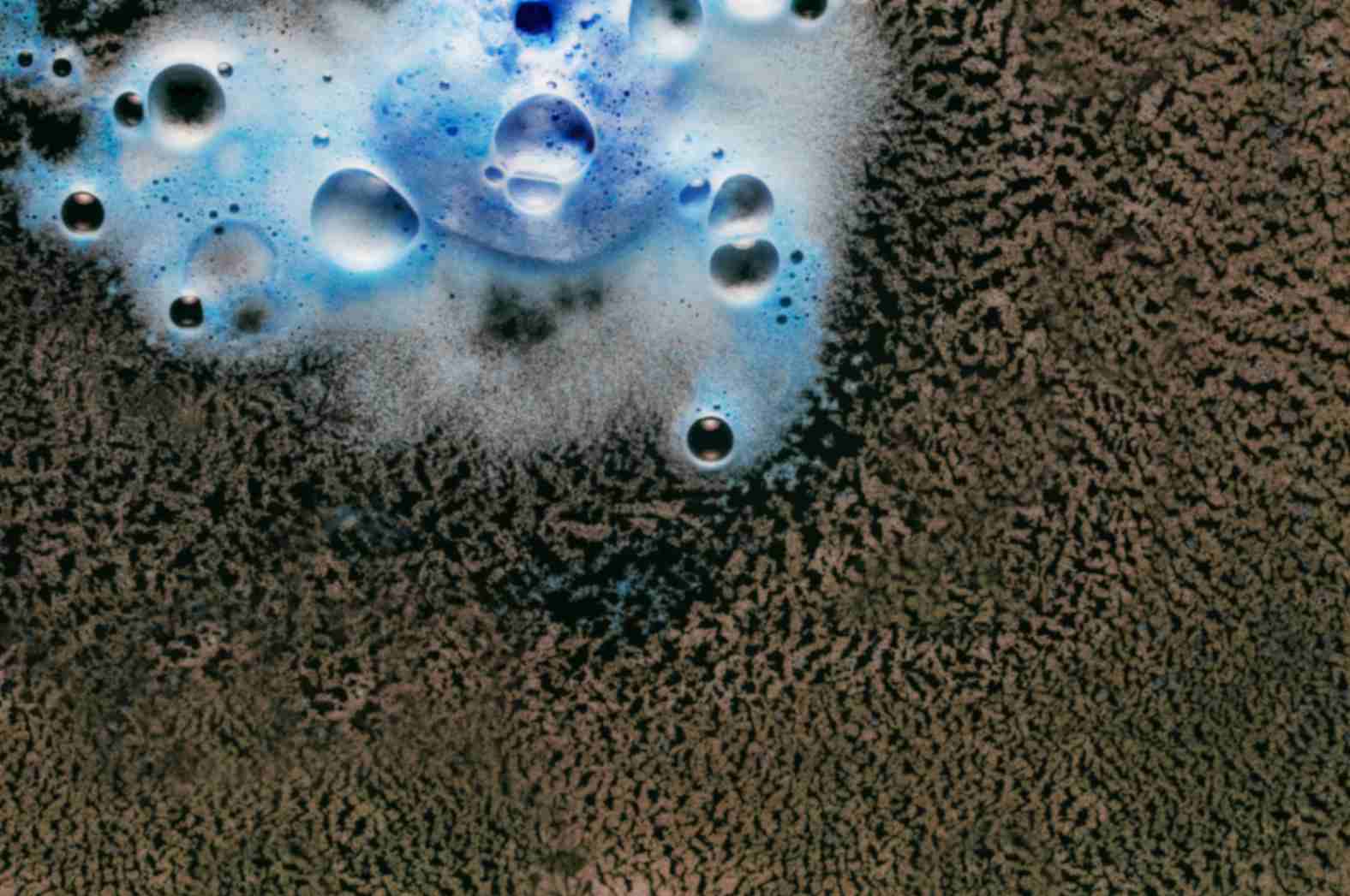 “Close-up of a bath mat being cleaned with solution, showing foam on a wet surface